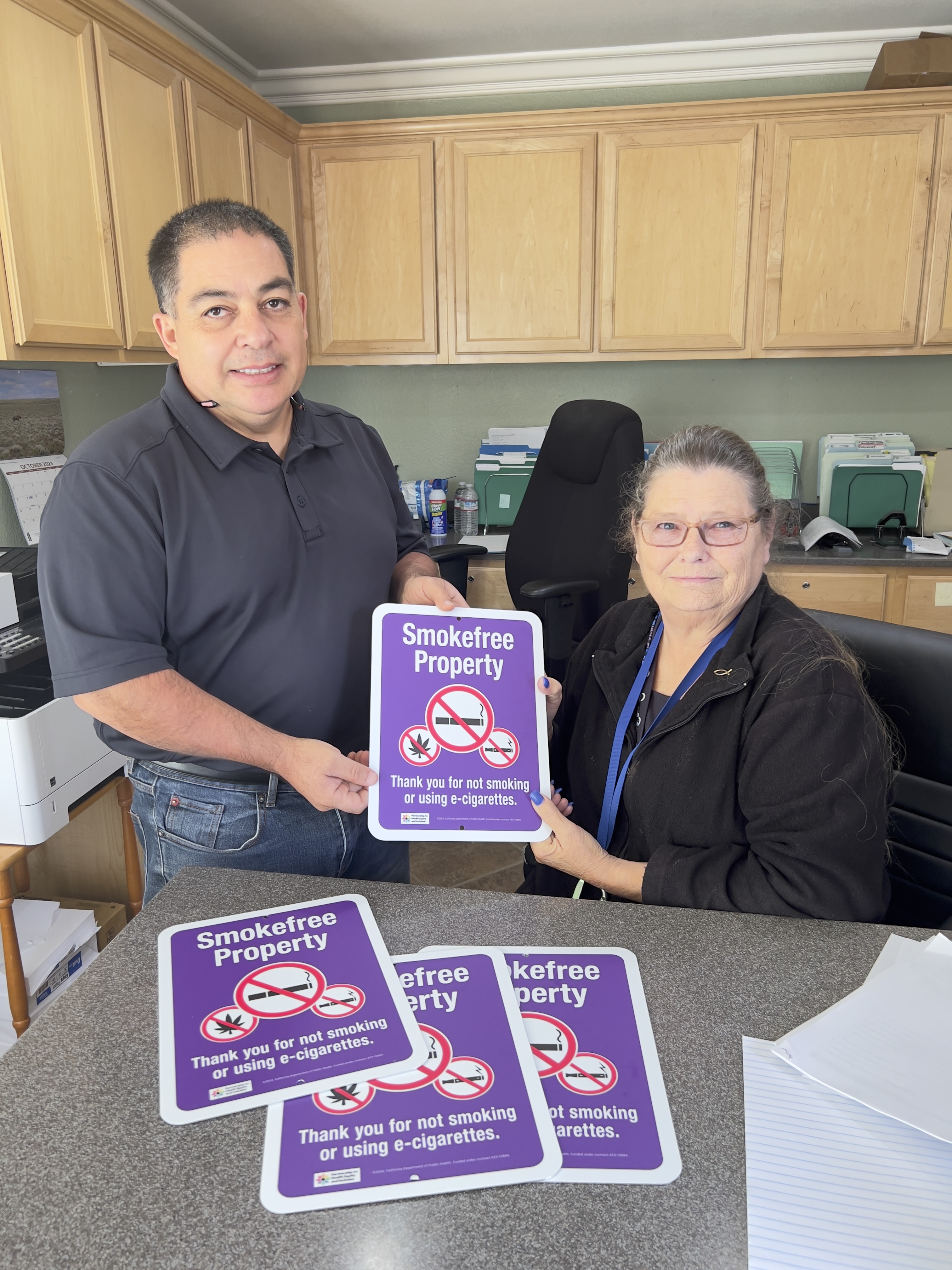 CAN staff holding smoke-free signs.