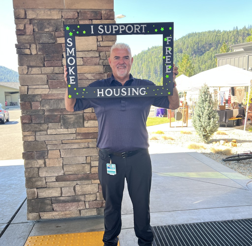 Man holding a u0022I support smoke free housingu0022 sign